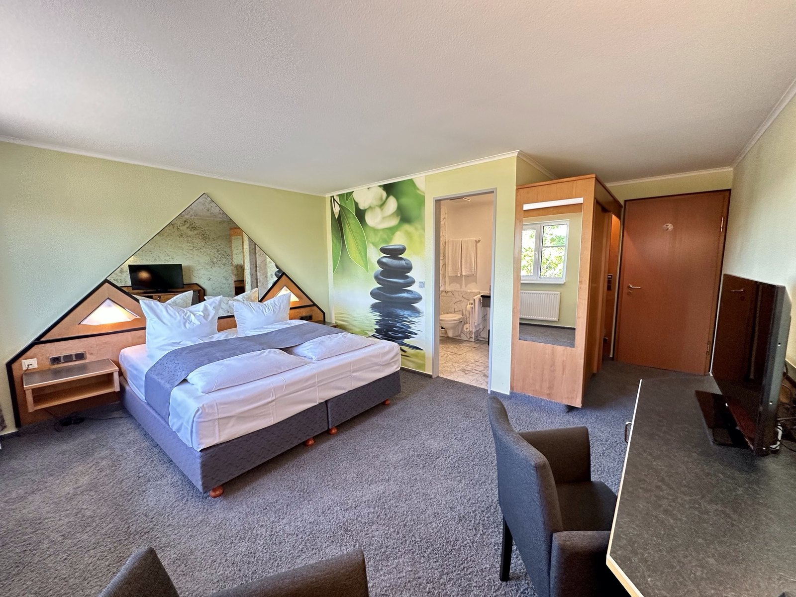 Gästezimmer mit bezogenem Bett und Sitzecke